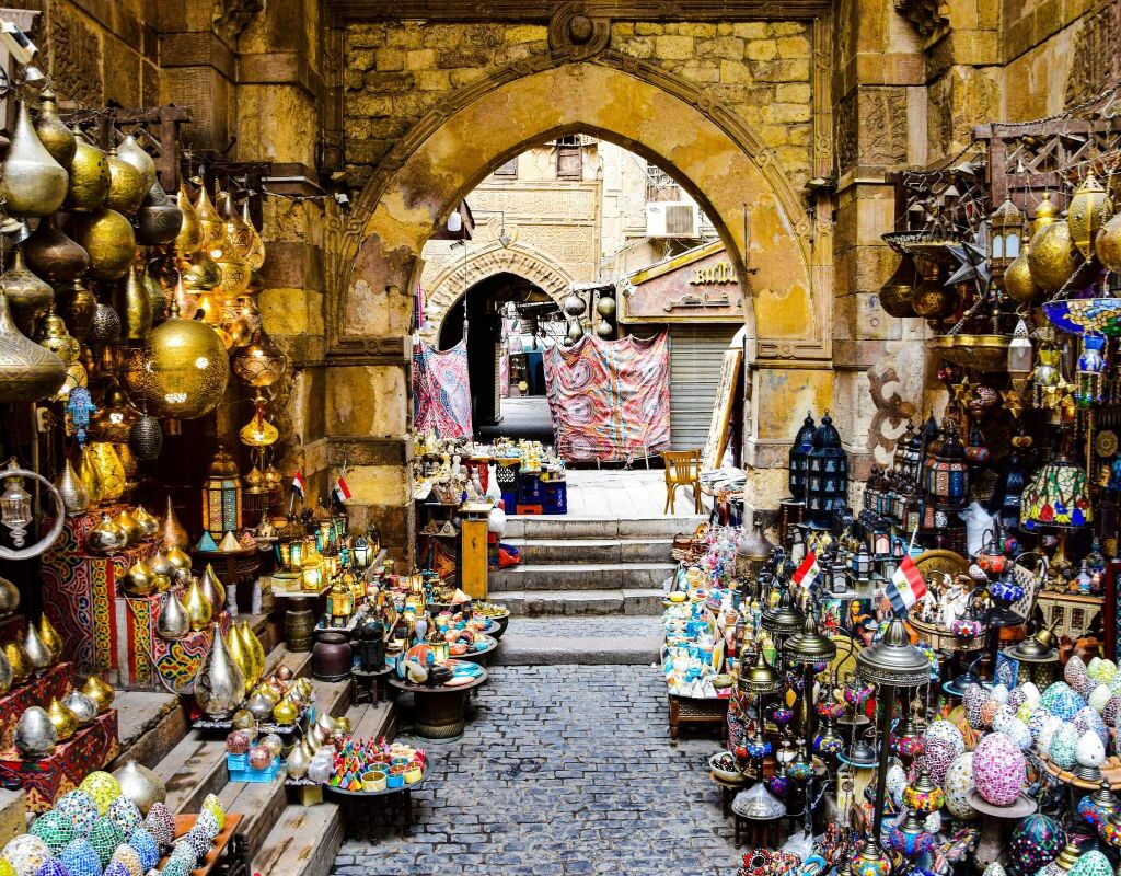 A vibrant scene at Khan El Khalili Market in Cairo with colorful lanterns, spices, and traditional handcrafted goods