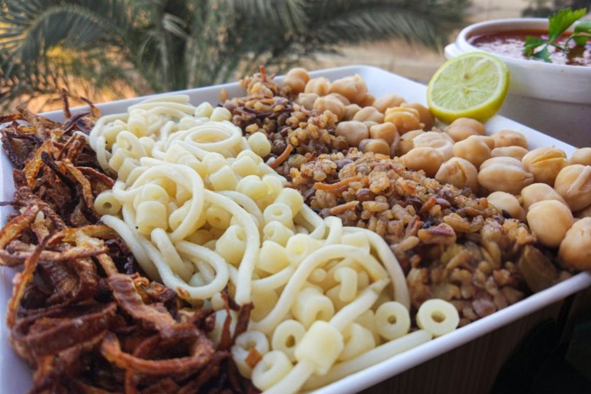 Traditional Egyptian Koshari dish with rice pasta lentils chickpeas and crispy fried onions served in a bowl