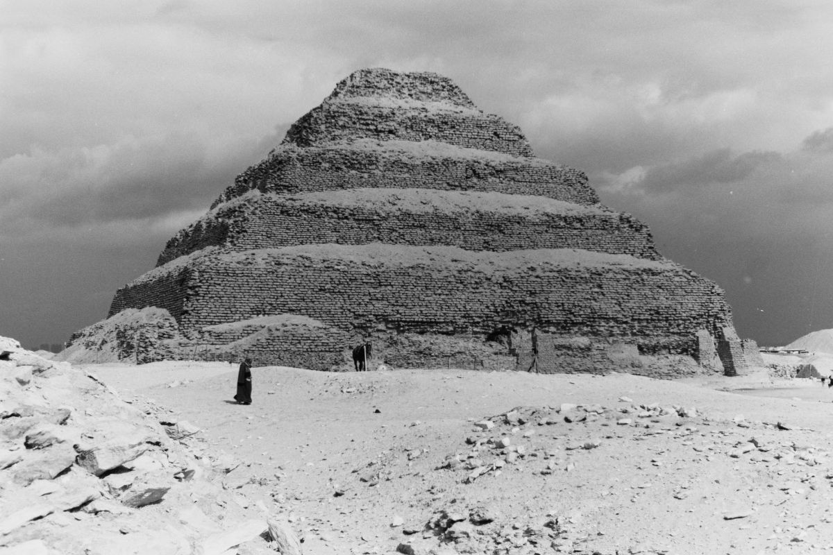 The Step Pyramid of Djoser at Saqqara standing against a clear blue sky showcasing its ancient architectural design